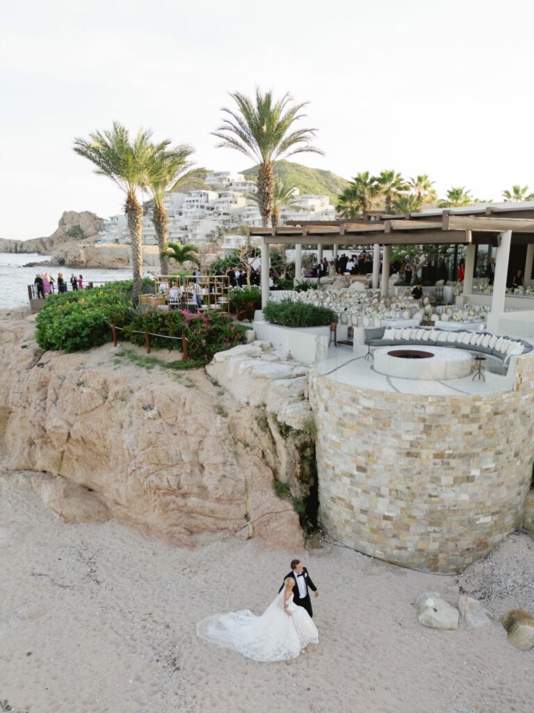 Katya Ruiz and groom walk beachside in couture gown.