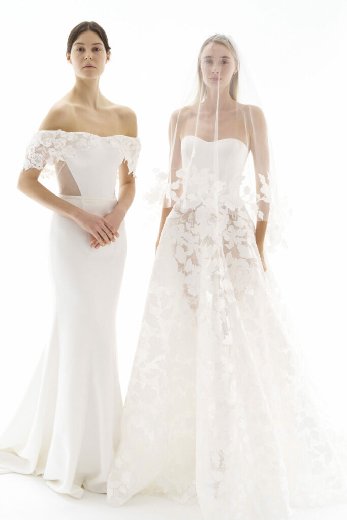 Ness & Nessia wear white bridal gowns, side by side.
