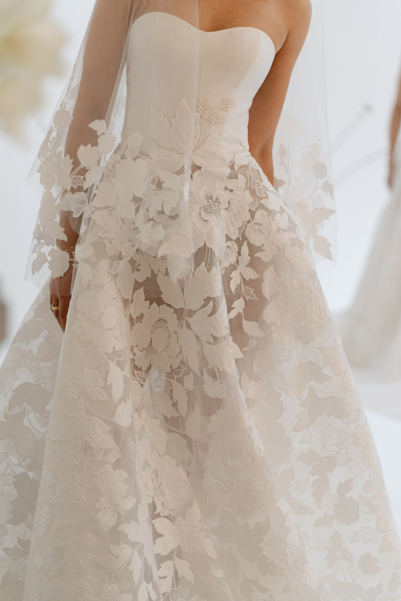 Bride in strapless white lace wedding gown, close-up.