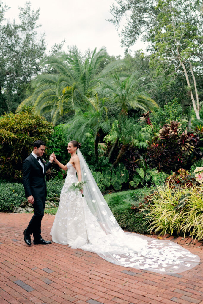 Bride and groom walking together in garden patio.