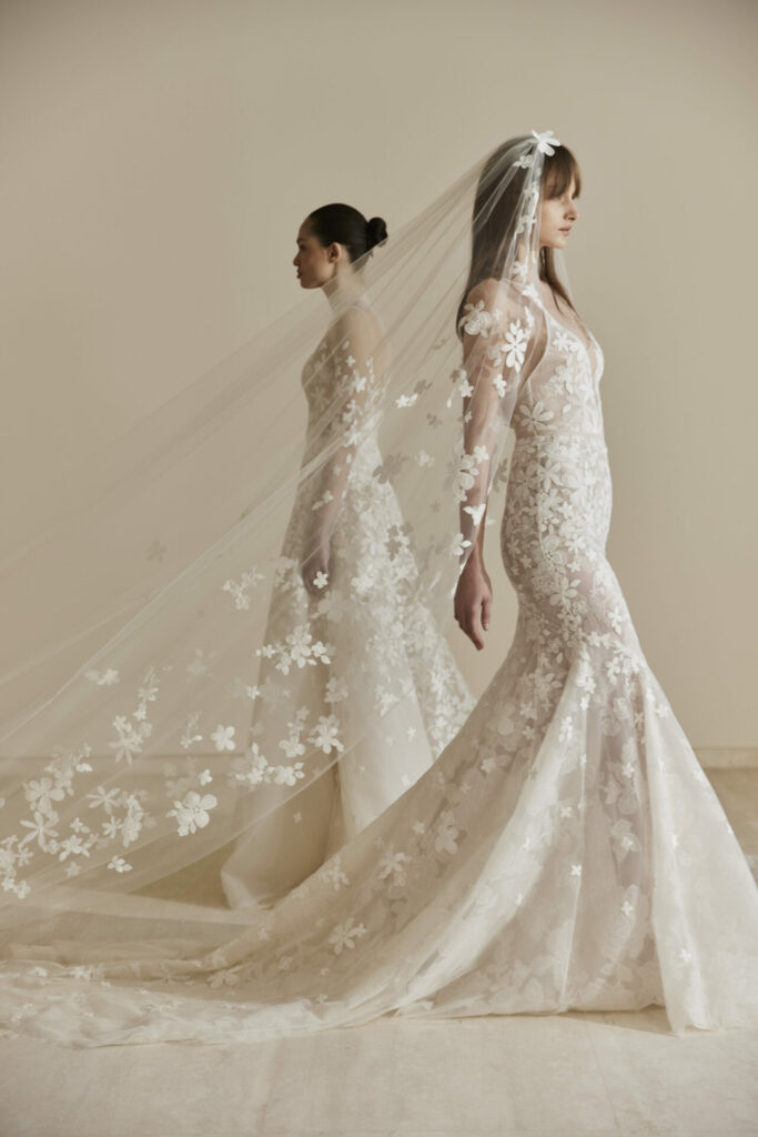 Two women in floral lace wedding gowns and veils.