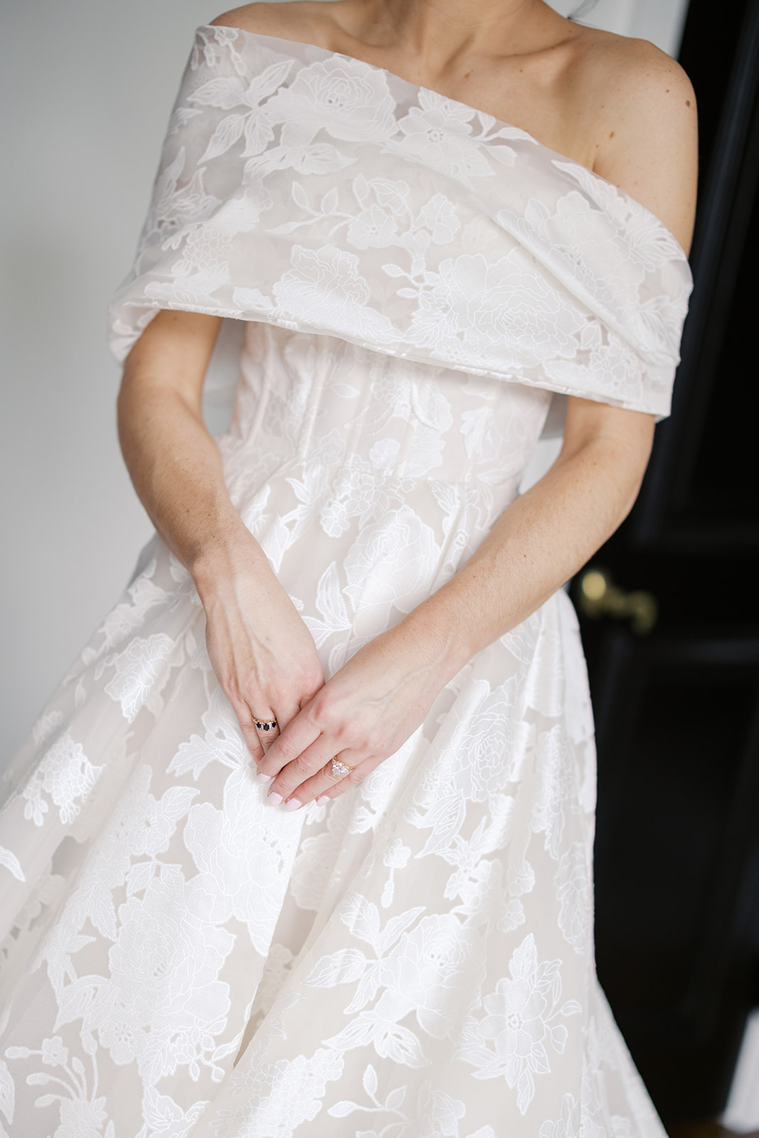 Woman in white lace wedding dress, face hidden.