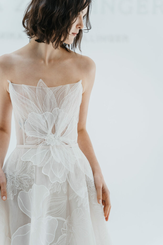 Woman in sheer, strapless floral white dress.