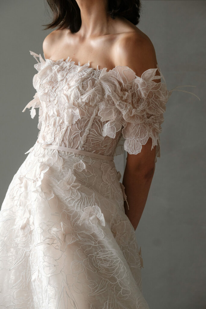 Woman in pink floral dress, face unseen.