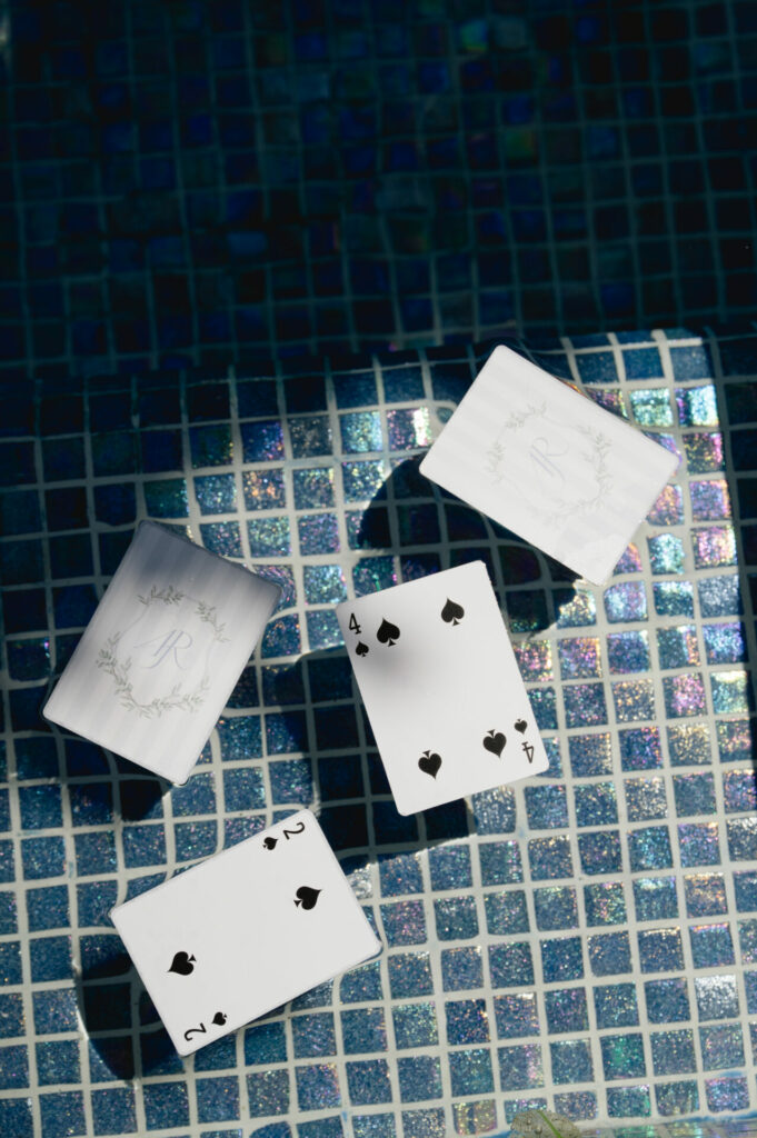 Four cards on blue tiles, two spades revealed, shimmering light.
