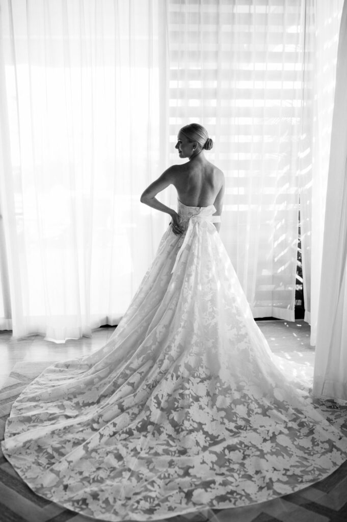 Katya Ruiz in lace gown, back turned, soft light.