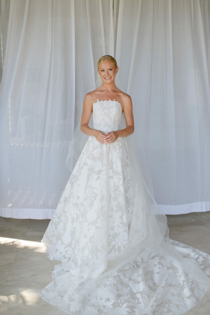 Katya Ruiz smiles in glowing strapless Mira Zwillinger gown.