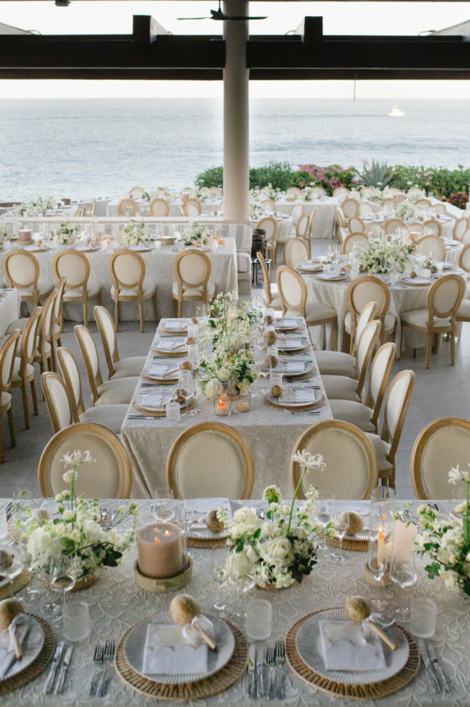 Sunset ocean wedding, chic tables, luxe bridal details.