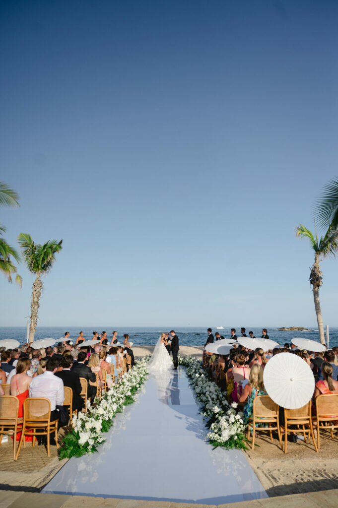 Bride Katya Ruiz weds on a sunny beach aisle.