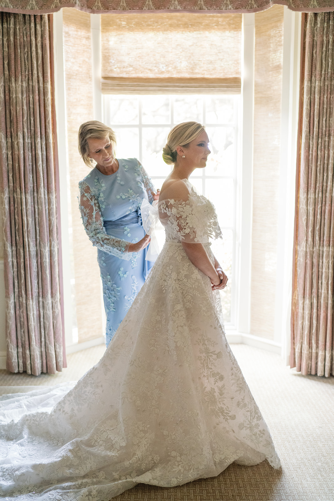 Two women stand together in chic dresses.