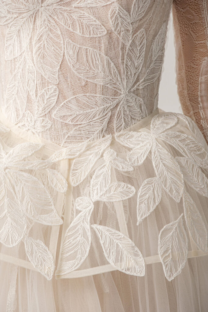 Beige tulle wedding dress with white floral embroidery.