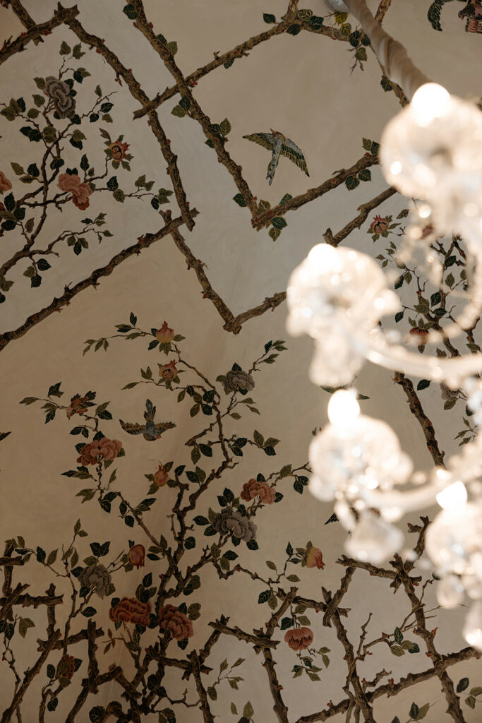 Floral and bird ceiling, crystal chandelier, elegant ambiance.