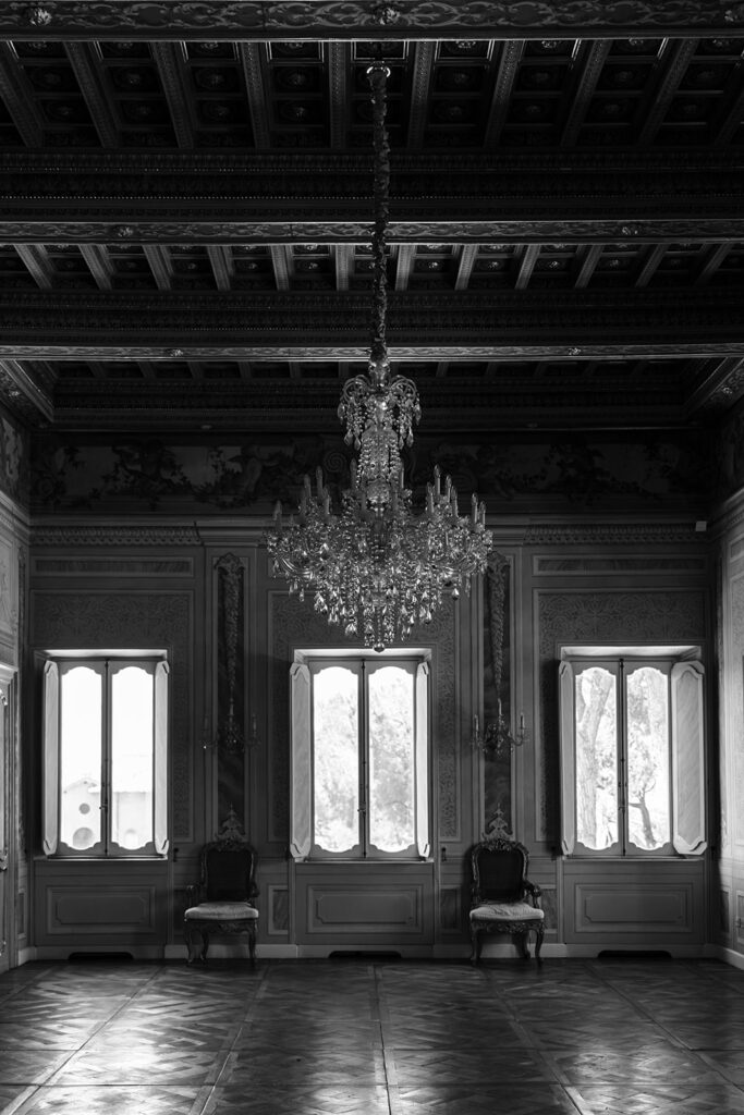 Ornate, elegant room with chandelier and antique chairs.
