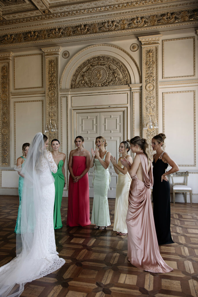 Katya Ruiz in couture gown with bridesmaids, smiling.