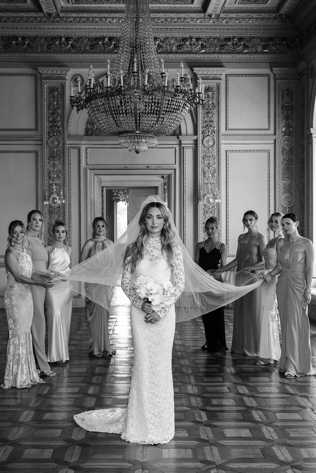 Katya Ruiz in couture gown, veil held by bridesmaids.