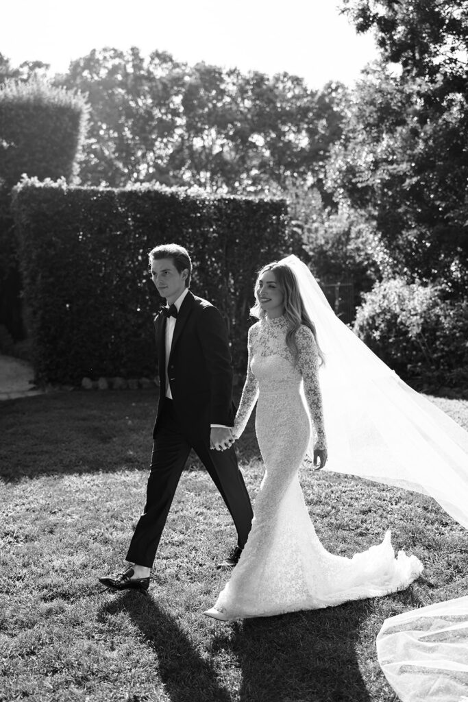 Katya Ruiz and groom smile, hand-in-hand outdoors.