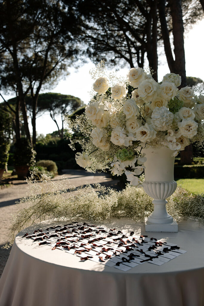 Elegant outdoor table with white flowers, name cards.