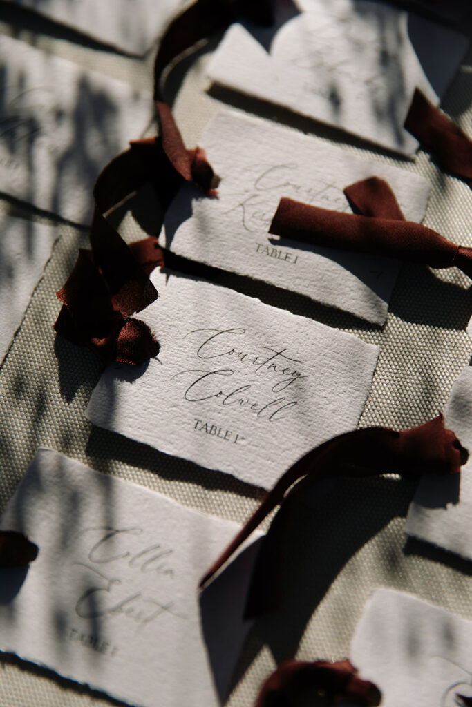 Textured place cards with ribbons, chic bridal setting.