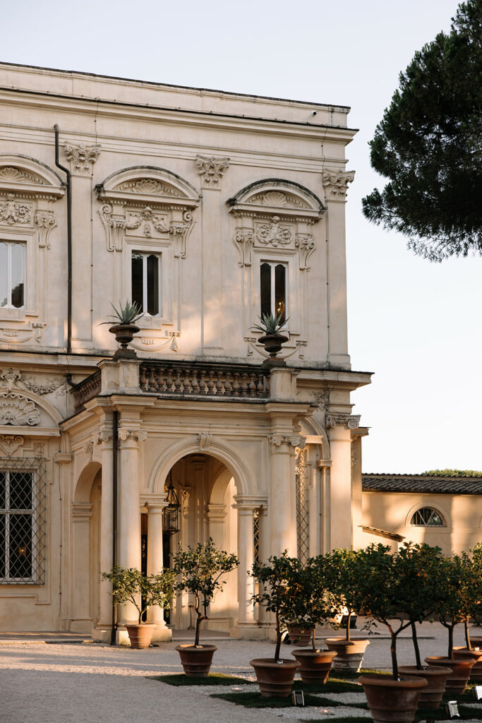 Historic building, arched entry, potted oranges, couture bride.