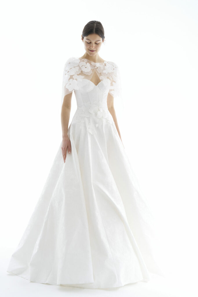 Woman in SS2026 white wedding dress with floral cape.