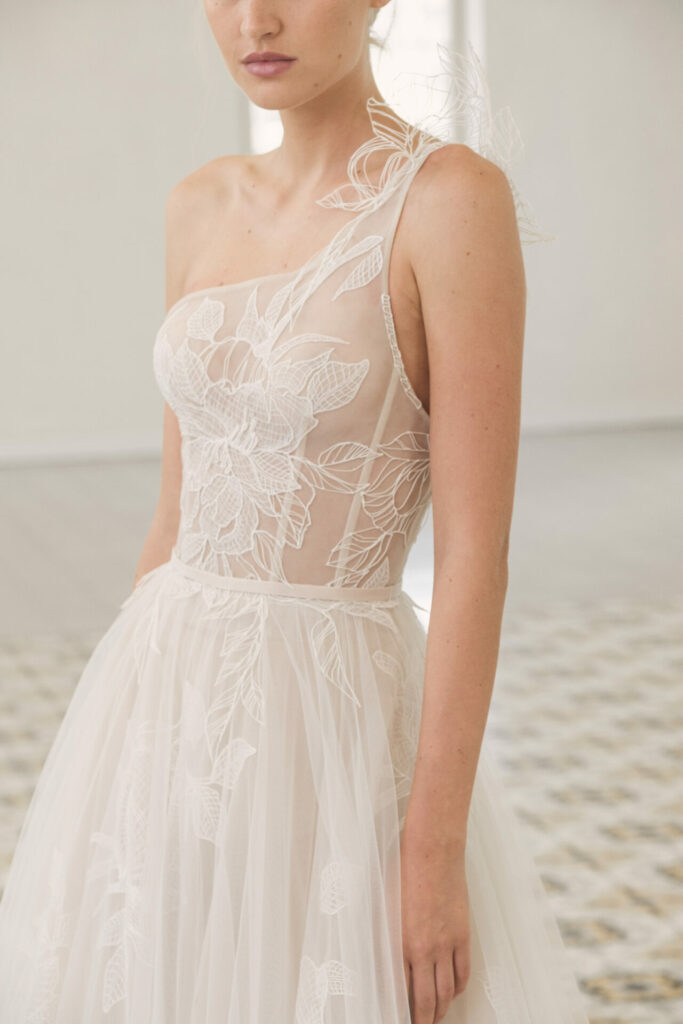 Woman in one-shoulder tulle gown, partial face visible.