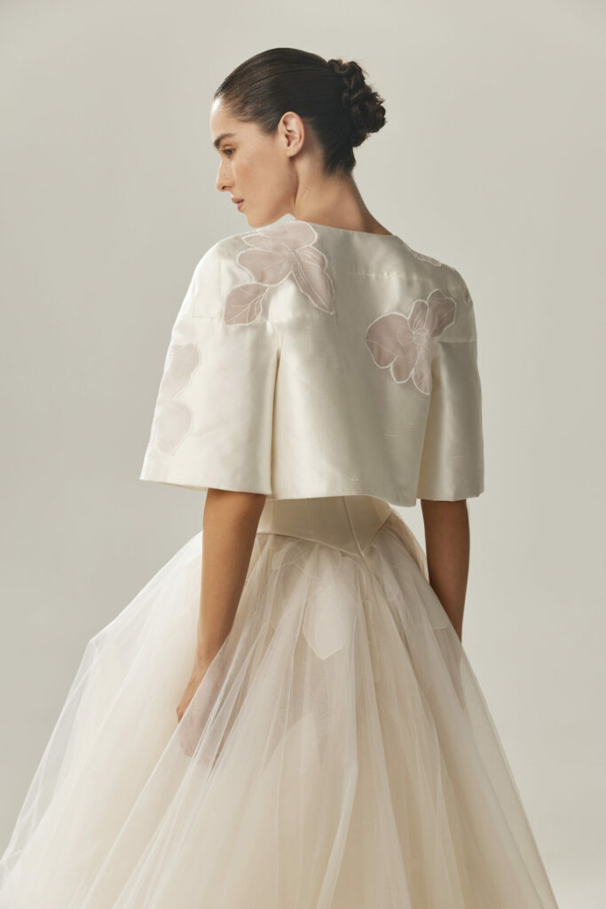 Bride in tulle gown and satin cape, 2026 style.