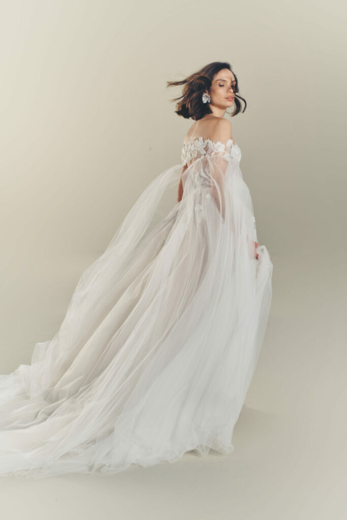 Woman in elegant tulle gown turns gracefully, ethereal.