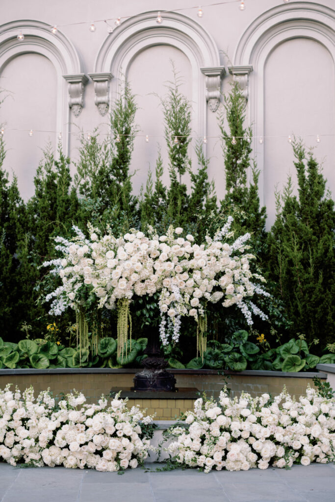Elegant wedding setup: white flowers, greenery, string lights.