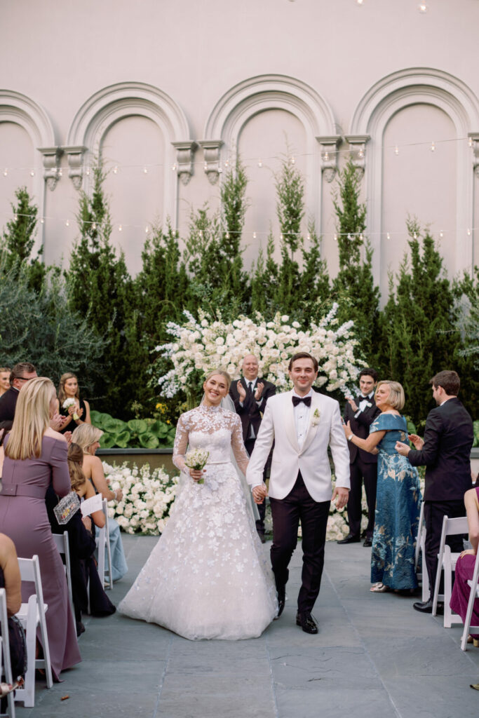 Bride Katya Ruiz and groom exit, smiling as guests applaud.