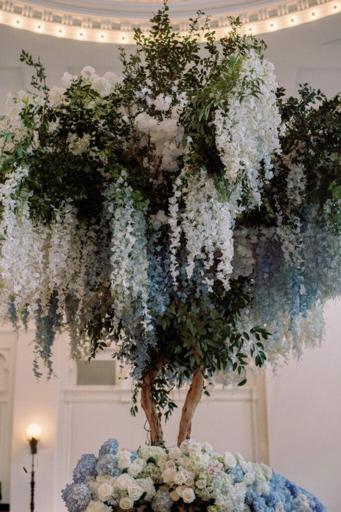 Elegant tall arrangement with cascading blue and white blooms.