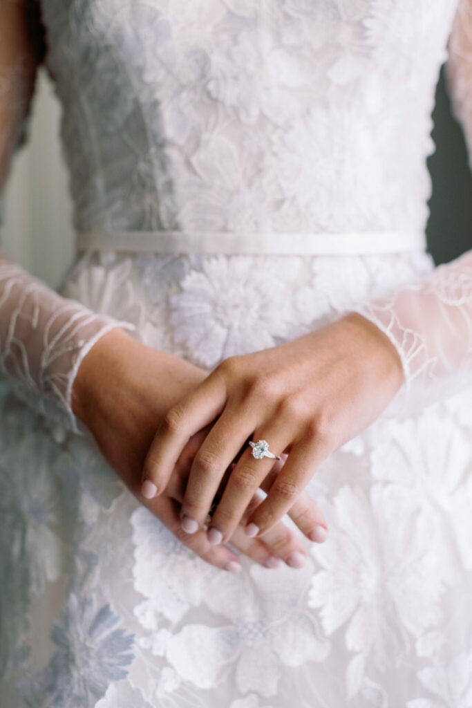 Katya Ruiz in lace gown, clasped hands, diamond ring.