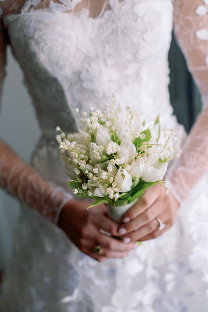 Katya Ruiz in floral lace gown with white bouquet.