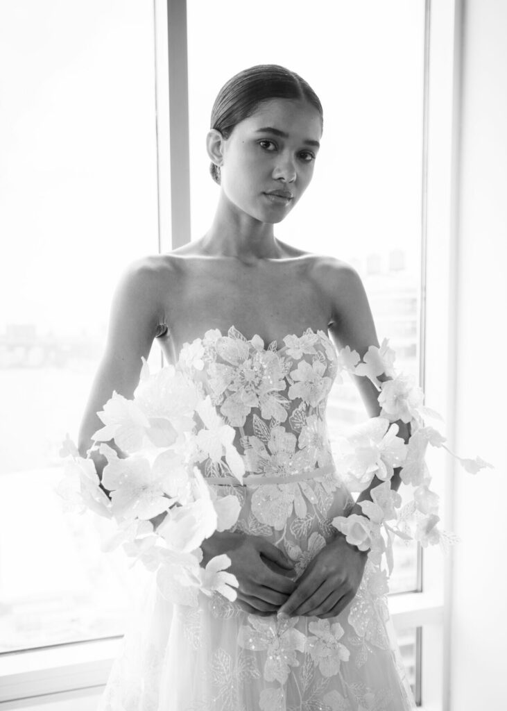 Woman in strapless gown, black-and-white, by window.