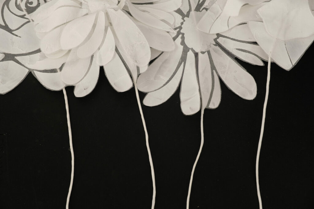 White abstract flowers with thin stems on black background.