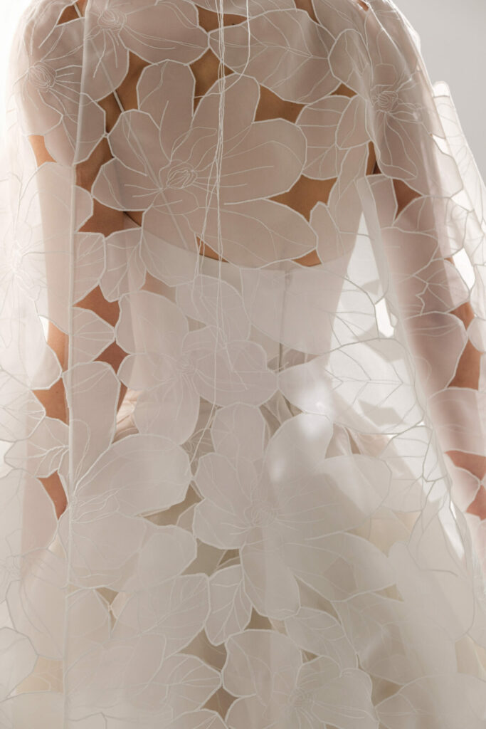 Sheer white floral garment over soft dress, SS2026 couture.