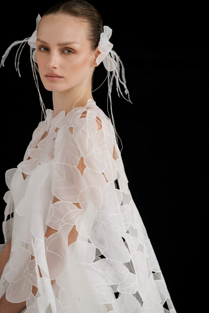 Woman in sheer floral couture, matching headpieces.