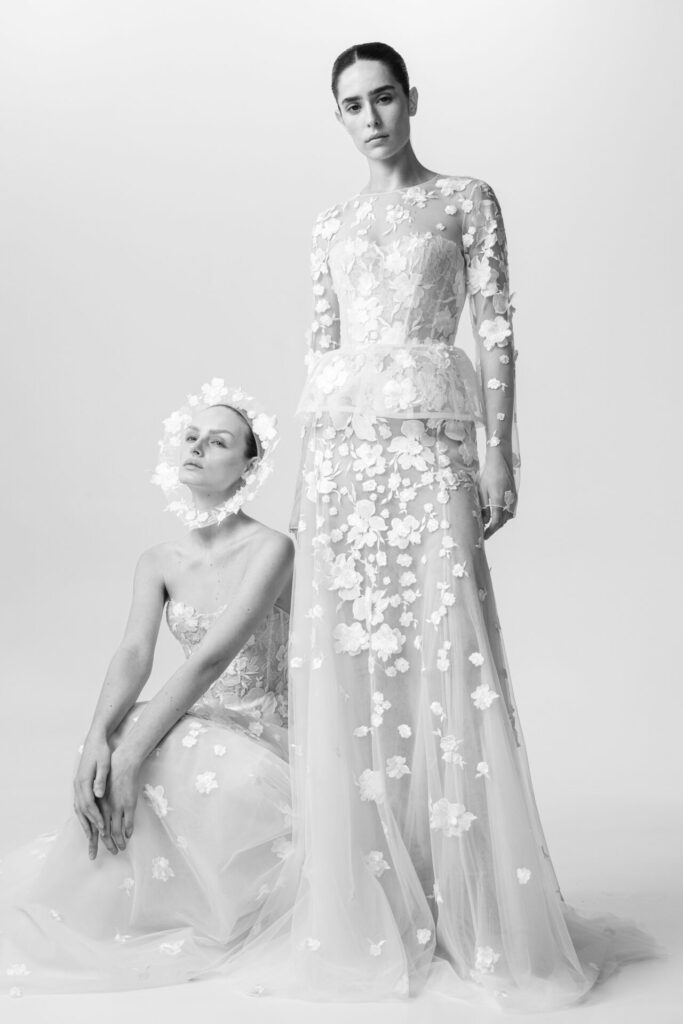 Women in sheer couture gowns with floral appliqués.