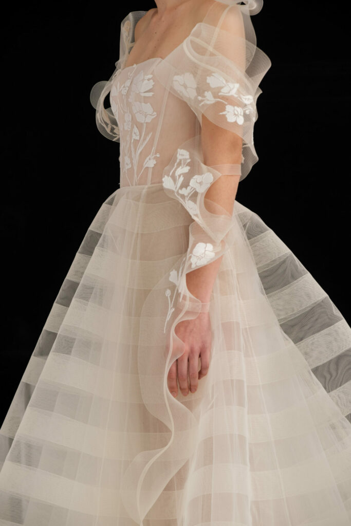 Sheer embroidered gown with ruffled sleeves and skirt.