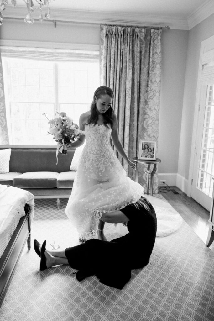 Katya Ruiz in Mira Zwillinger gown, dress adjusted in elegant room.
