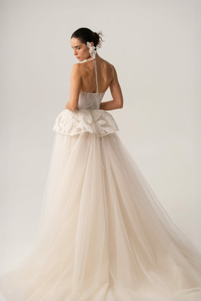 Woman in strapless white wedding gown, turning back.