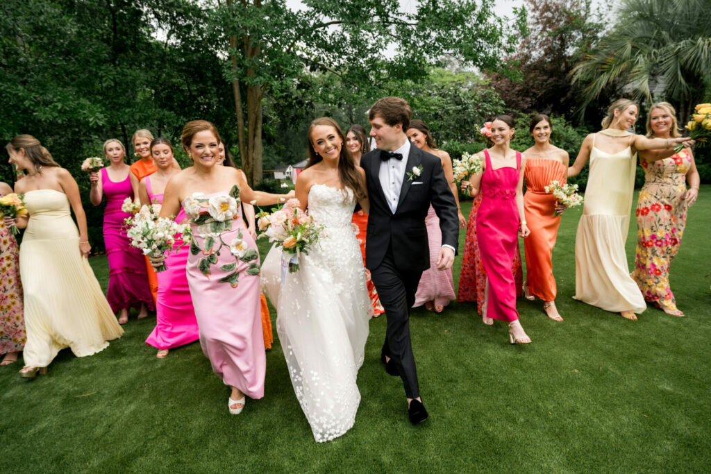 Bride, groom, and bridesmaids in luxury couture outdoors.