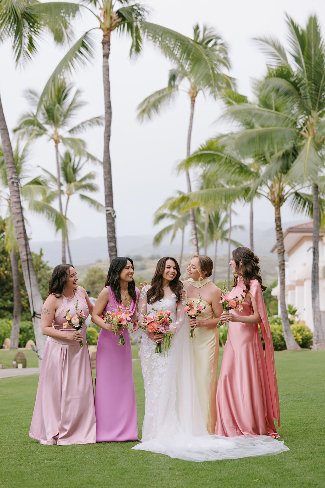 Taylor and her bridesmaids laugh among palm trees at her Mira Zwillinger Kapolei wedding