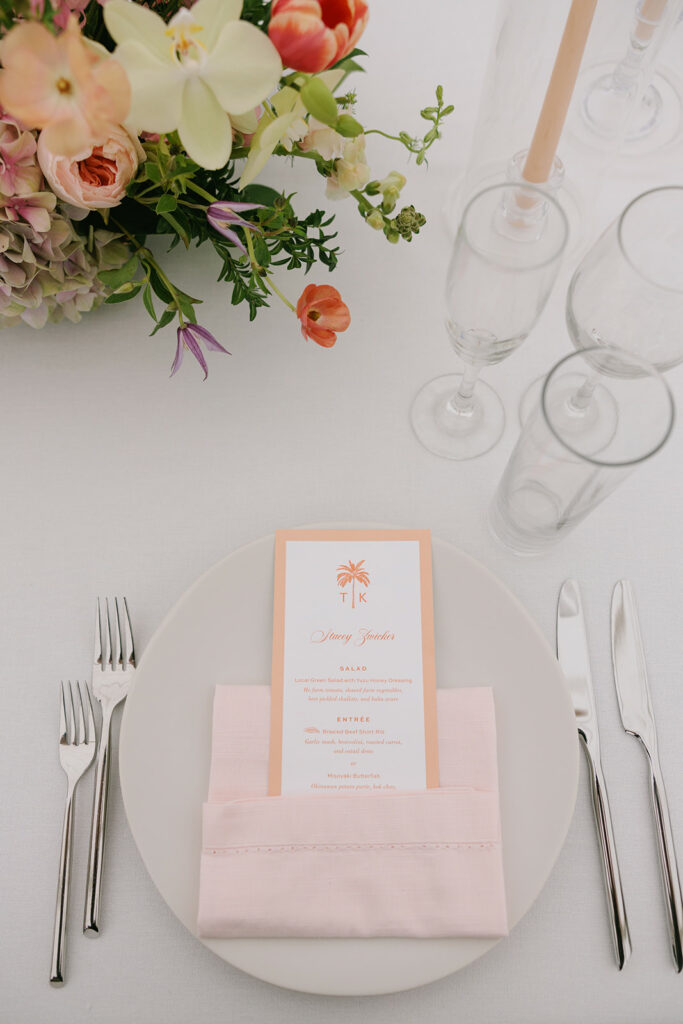 Elegant wedding table with pink napkin, menu, flowers, and glassware at Taylor's Kapolei wedding