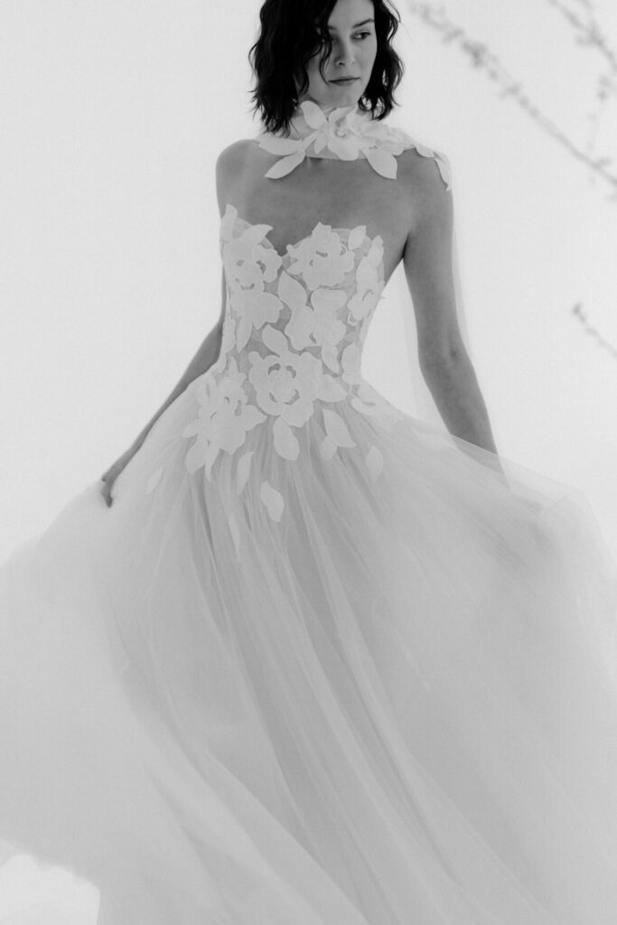 Woman in strapless floral wedding dress, ethereal black-and-white.