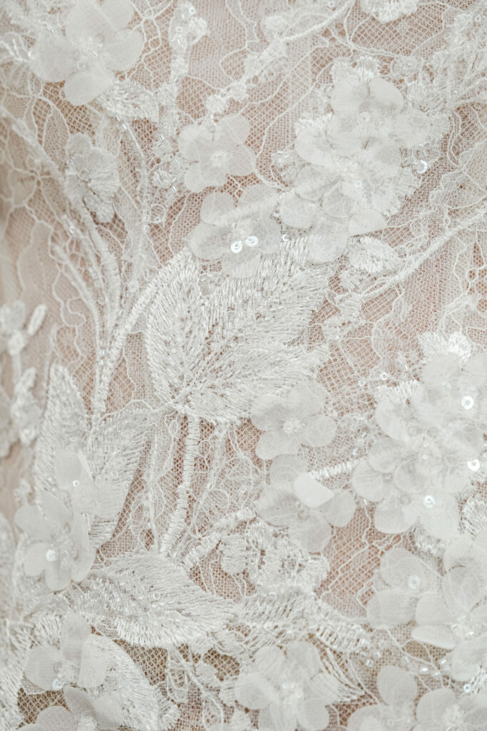 White lace fabric with floral embroidery and sequins.