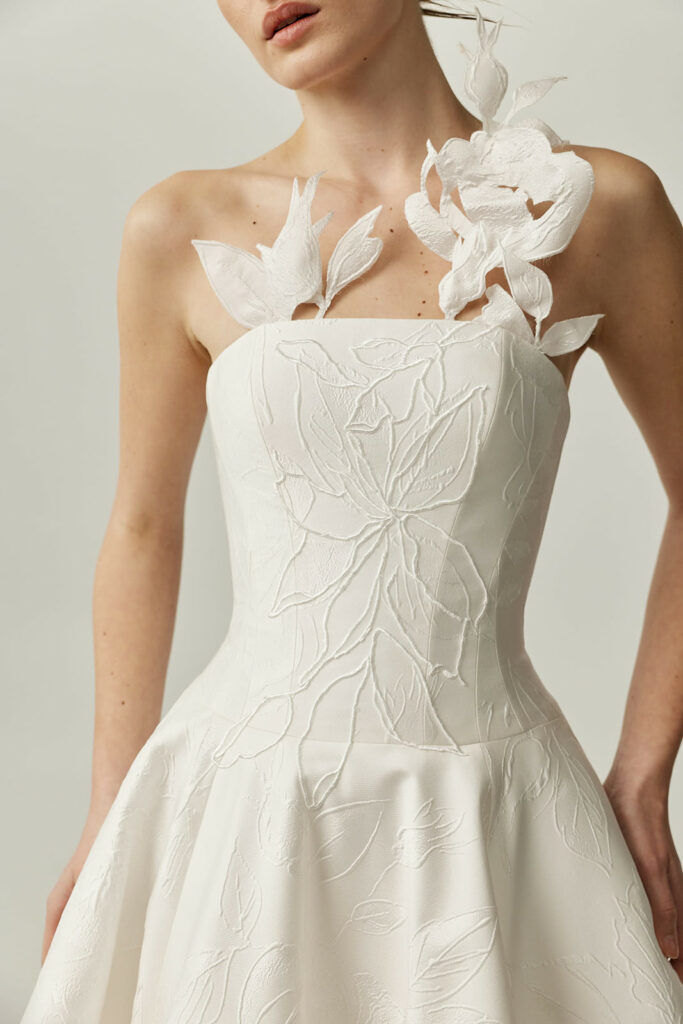 Woman in white strapless floral couture dress, SS2026.