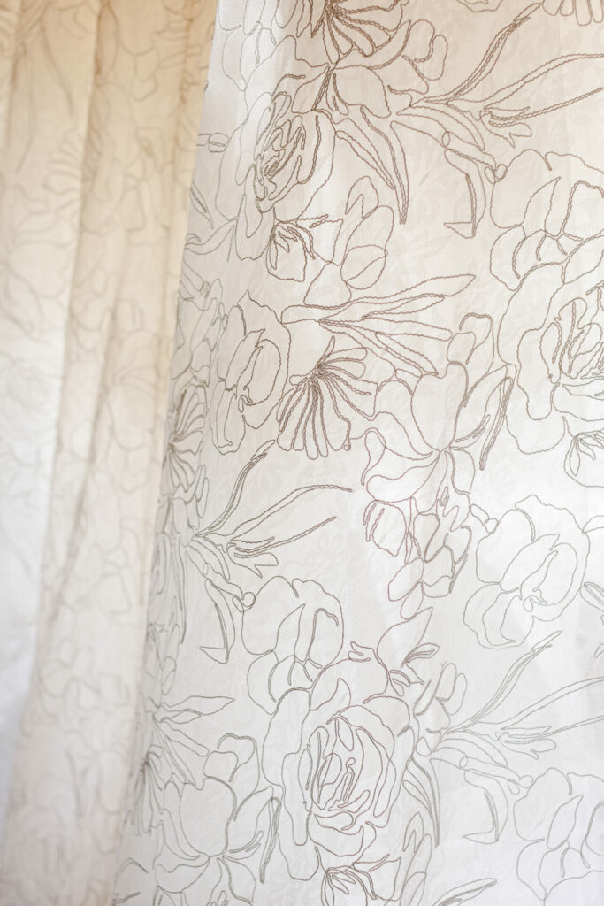 Sheer floral curtains softly lit, bridal couture style.