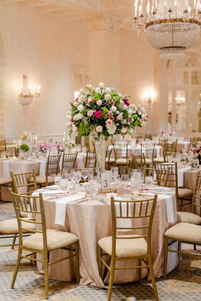 Dreamy wedding hall with pink centerpieces, chandeliers.