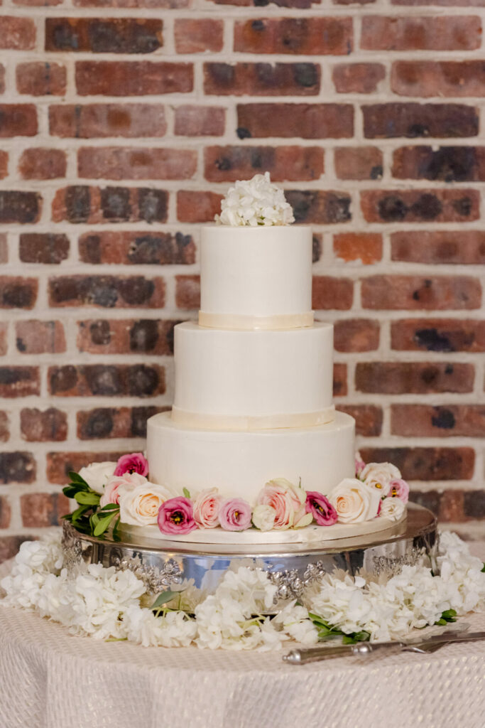 Elegant white wedding cake with pink flowers.