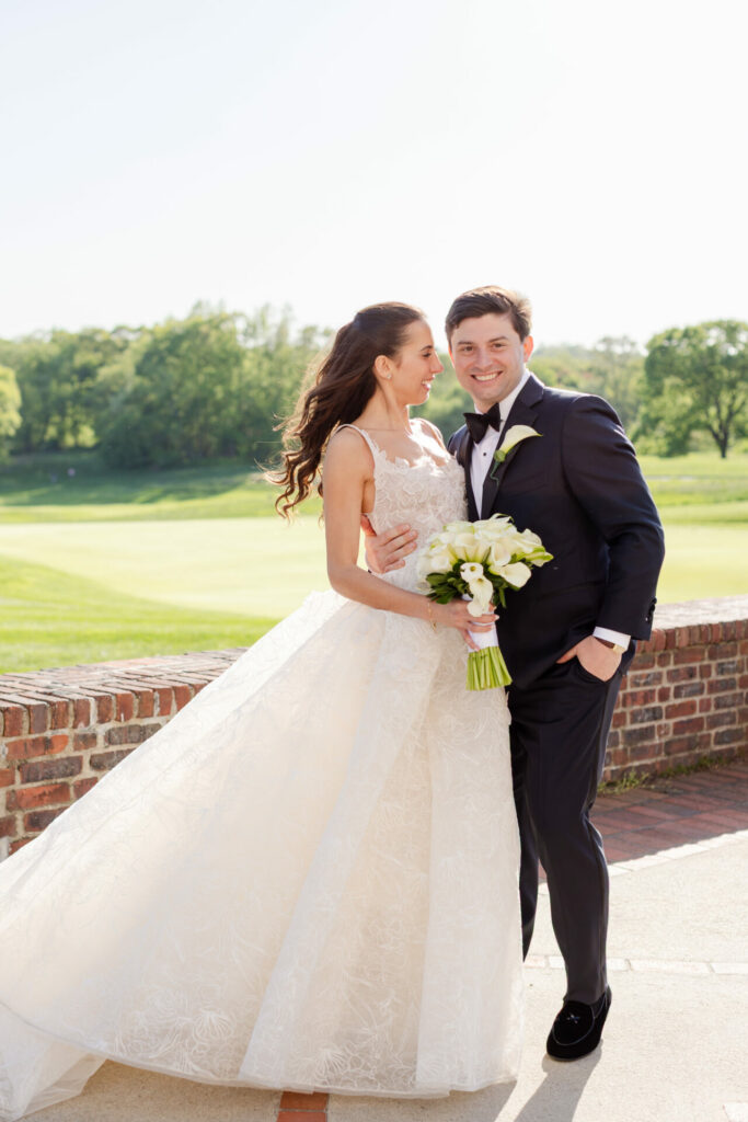 Katya Ruiz in bridal gown smiles with groom outdoors.